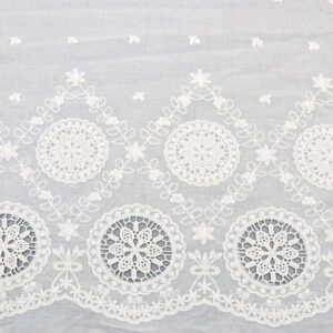 A white lace tablecloth featuring a large flower design, made from Starburst Medallion cotton lace fabric