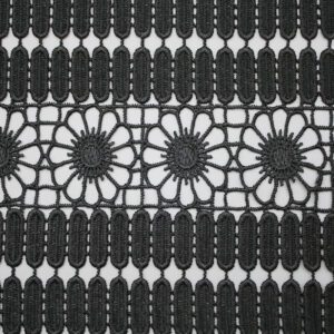 Black and white photo showcasing an intricate pattern of polyester corded lace fabric