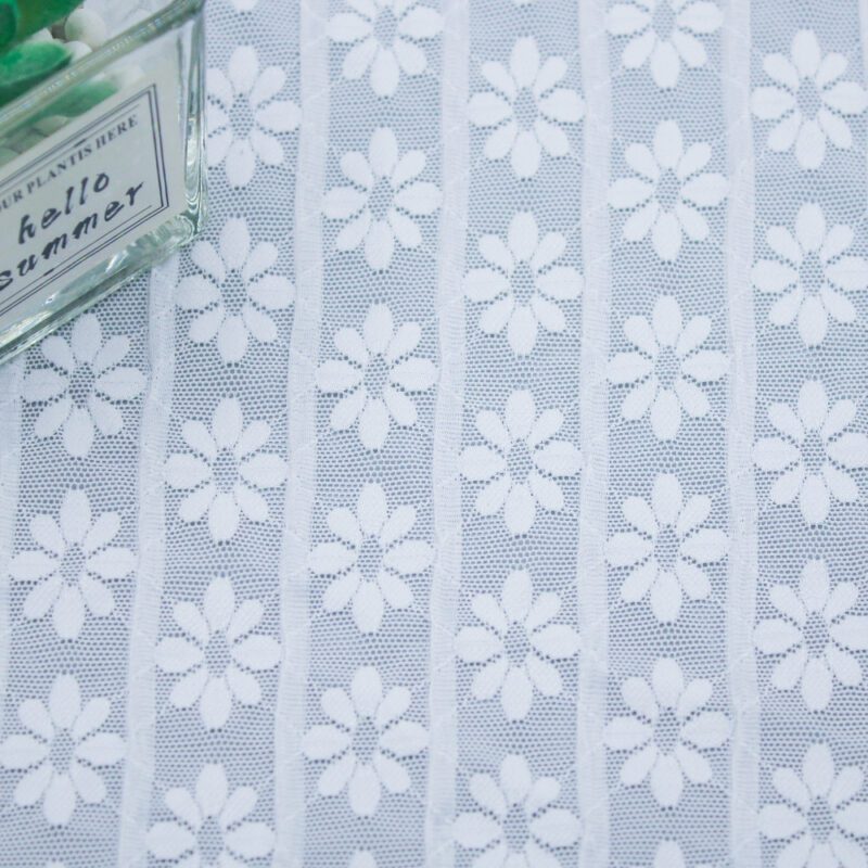 Elegant white lace fabric with floral designs, emphasizing its intricate patterns and delicate texture