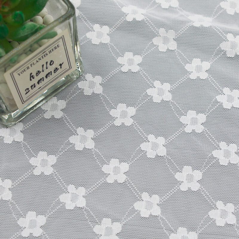 White and gray nylon and spandex lace fabric featuring a floral pattern with white flowers