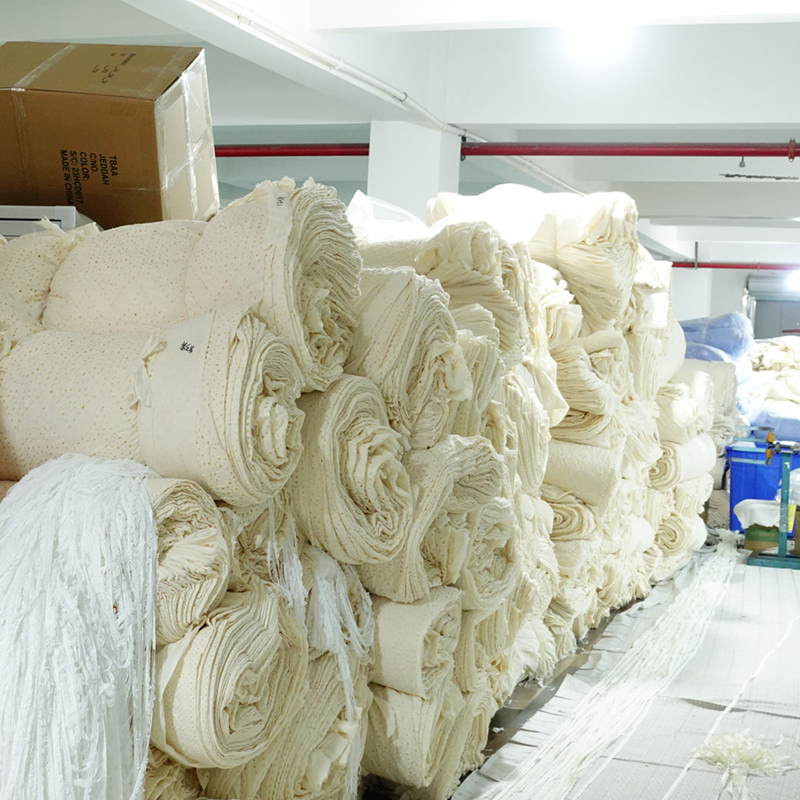 A large pile of delicate white lace fabric, showcasing intricate patterns and textures