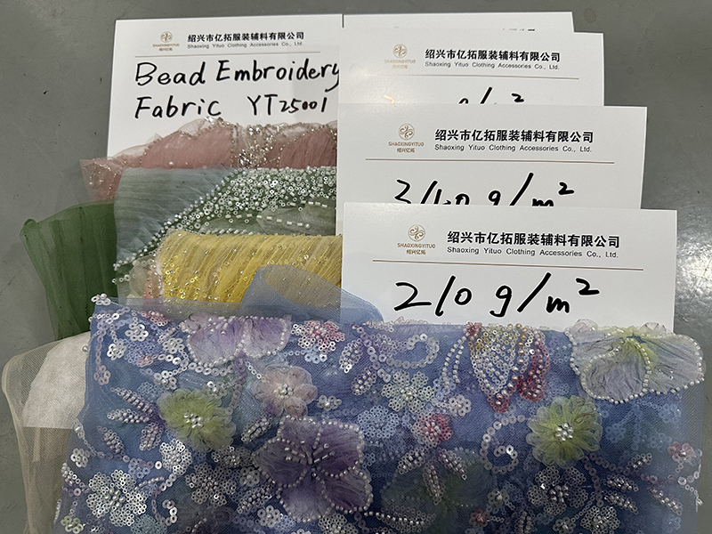 A bag containing various beaded lace fabric samples in multiple colors and designs
