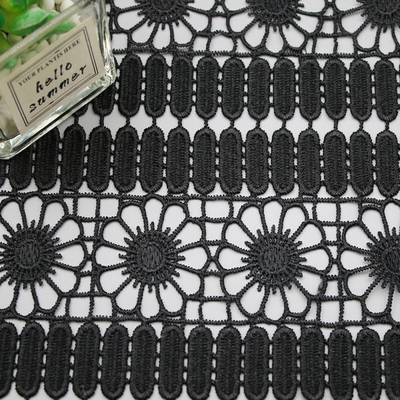 A detailed black and white image of a lace pattern made from polyester corded fabric