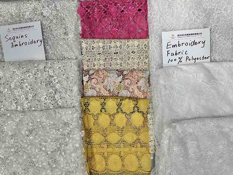 A display of various lace and fabric types, featuring a free lace fabric sample prominently showcased