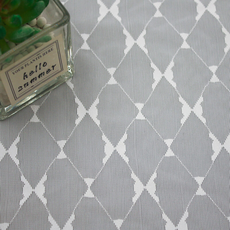 A gray and white rug with a diamond pattern, crafted from nylon and spandex lace fabric