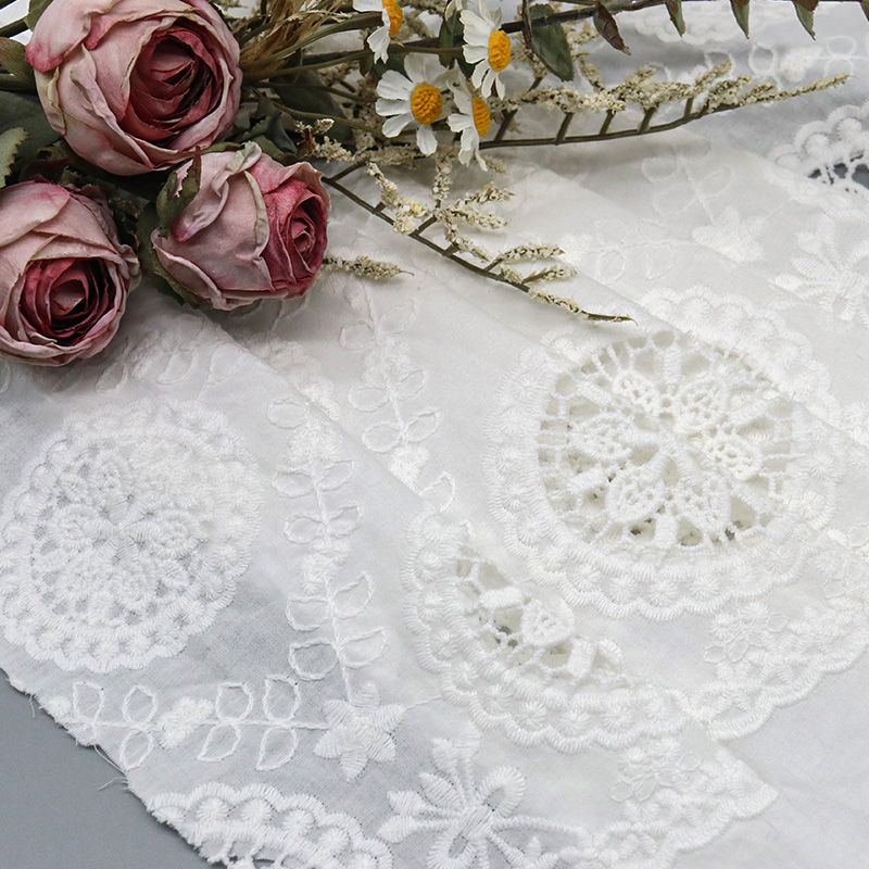 A white cotton lace tablecloth featuring an intricate large flower design