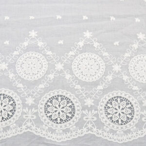 A white lace tablecloth featuring a large flower design, made from Starburst Medallion cotton lace fabric