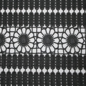 Black and white photo showcasing an intricate pattern of polyester corded lace fabric