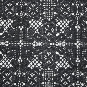 Black and white photo showcasing an intricate polyester lace pattern with delicate floral designs