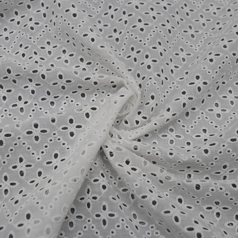 Classic white and black lace fabric featuring intricate patterns and decorative holes throughout