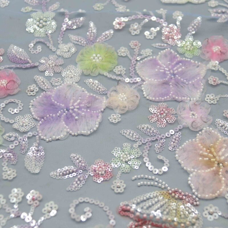 Close-up of polyester beaded lace fabric featuring colorful flowers and shimmering sequins