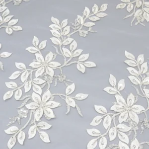 Close-up of white sequin lace fabric featuring intricate floral patterns and delicate textures