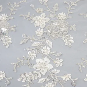 Close-up of white sequin polyester lace fabric featuring intricate floral patterns