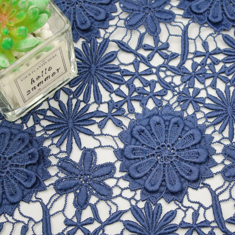 Detailed view of blue lace fabric with floral patterns, made from polyester rope embroidery