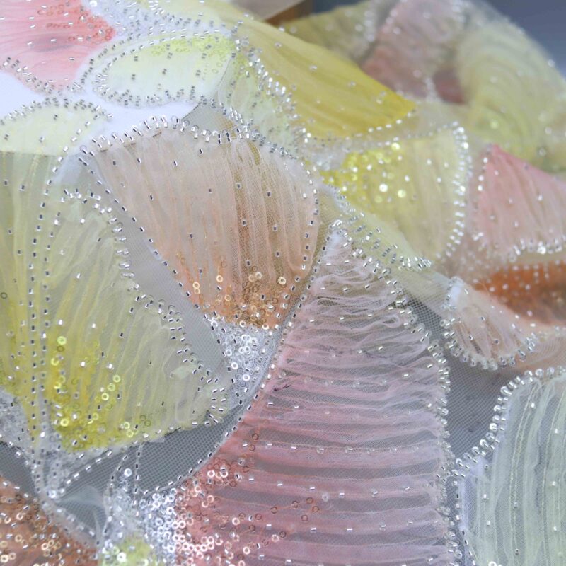 Detailed view of vibrant polyester lace fabric featuring sparkling sequins throughout