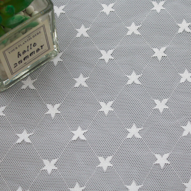 Embroidered lace fabric with a white star design on a gray background