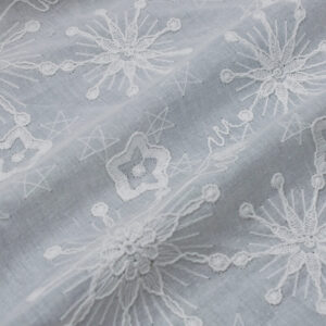 Embroidered white cotton fabric showcasing a decorative pattern