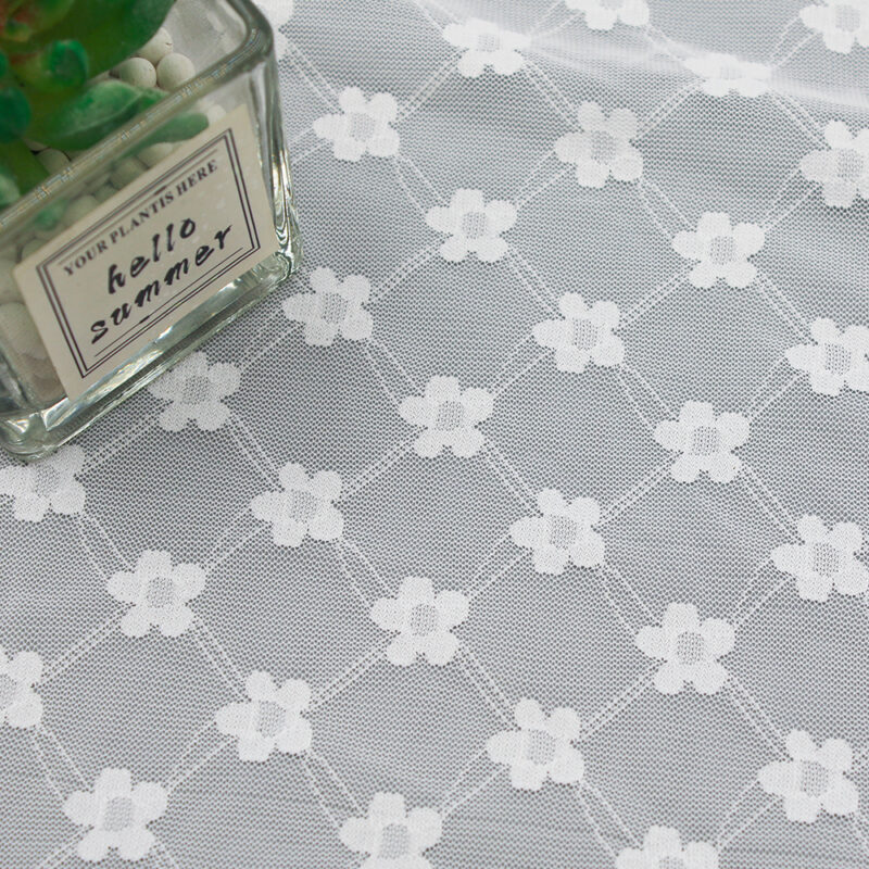 White and gray nylon and spandex lace fabric featuring a floral pattern with white flowers