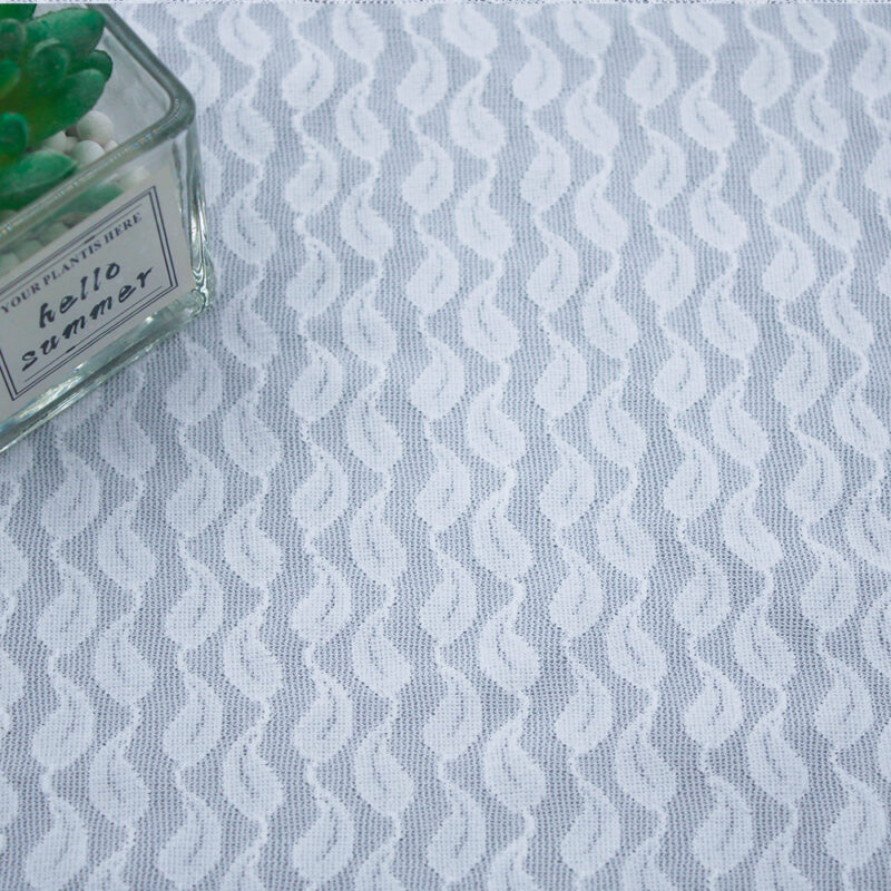 White and gray nylon and spandex lace fabric featuring an intricate embroidered pattern